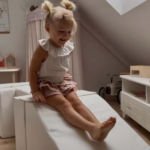 Dziecko ćwiczące równowagę na sztruksowej kładce z pianki – sensoryczny domowy tor przeszkód