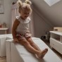 Dziecko ćwiczące równowagę na sztruksowej kładce z pianki – sensoryczny domowy tor przeszkód