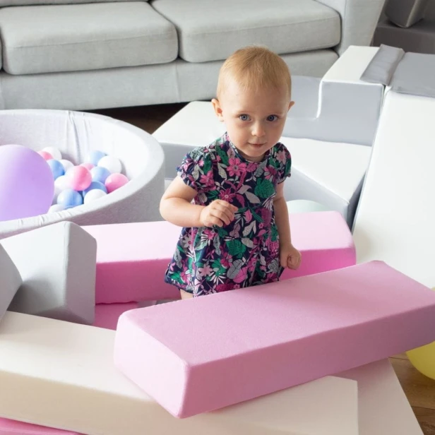 Dziecko grające w piankową wieżę Jenga – kreatywna i bezpieczna gra rodzinna w domu