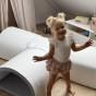 Dziecko raczkujące w miękkim tunelu z pianki w salonie